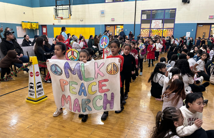  kindergarten students holding a banner that says MLK Peace March